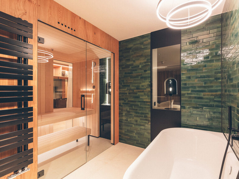 Badezimmer mit Badewanne, Dusche und eigener finnischer Sauna in der Wald Spa Suite-60 im Hotel Eibl-Brunner.