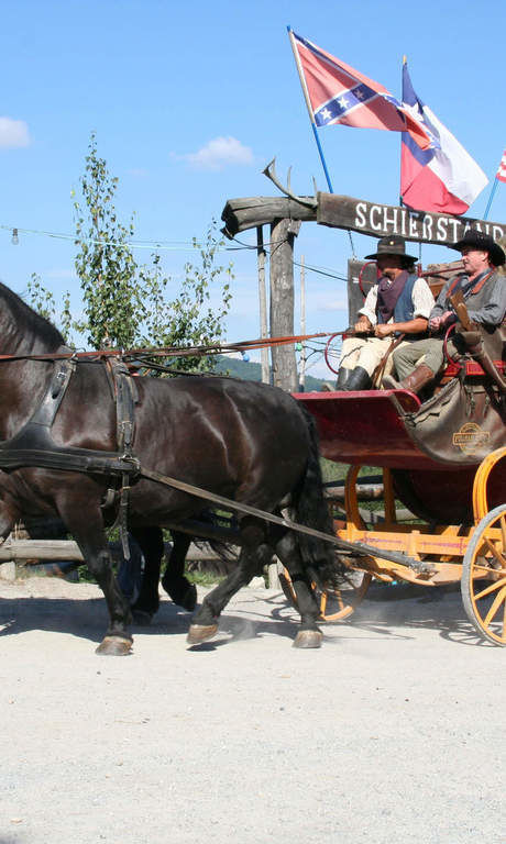 Eine Pferdekutsche die durch die Westernstadt Pullmann City, bei Eging am See fährt und eine der vielen weiteren Attraktionen in der belebten Westernstadt ist.