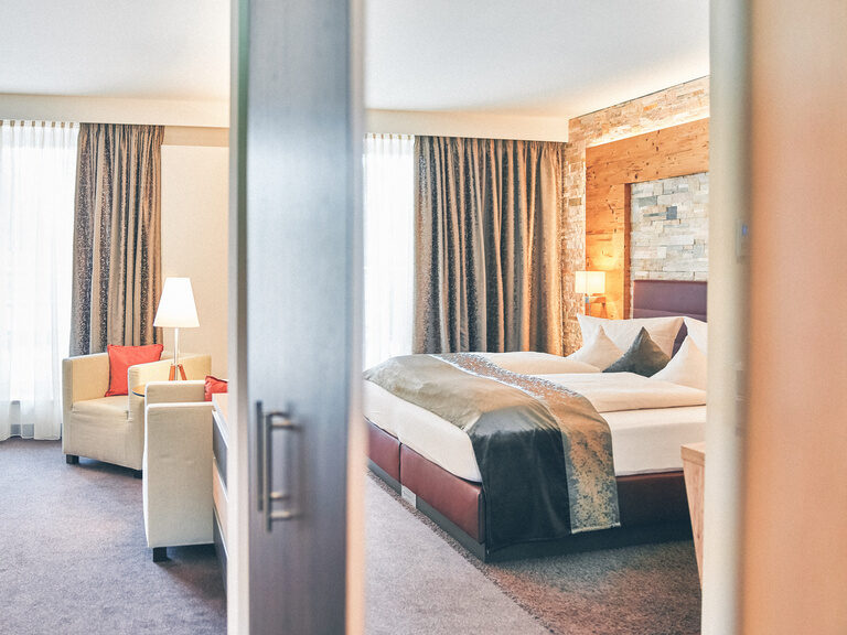 Doppelbett mit Spiegelung im Schrank des Bettes und Blick auf den Balkon im Doppelzimmer Falkenstein im Hotel Eibl-Brunner.