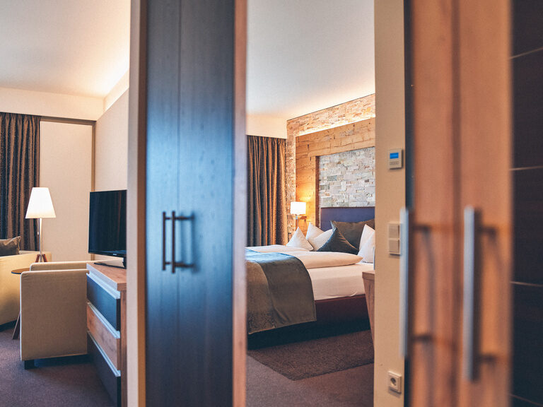 Doppelbett mit Spiegelung im Schrank des Bettes und Blick auf den Balkon im Doppelzimmer Falkenstein im Hotel Eibl-Brunner.