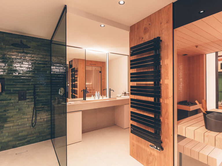 Großzügiges Badezimmer der WaldSPA Suite im Hotel Eibl-Brunner mit finnischer Sauna, großer Waschtisch und ebenerdiger Dusche.