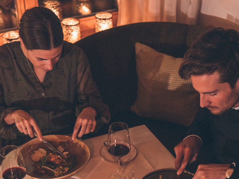 Romantisches Essen bei Kerzenschein mit zwei Personen, Brot, Wein und den Wildgerichten im Restaurant des Hotel Eibl-Brunner.