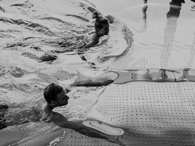 Paar beim schwimmen im Innenpool des Hotel Eibl-Brunner in schwarz-weiss.