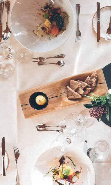 Ein für ein Menü gedeckter Tisch mit Vorspeisen für 4 Personen im Restaurant des Hotel Eibl-Brunner.