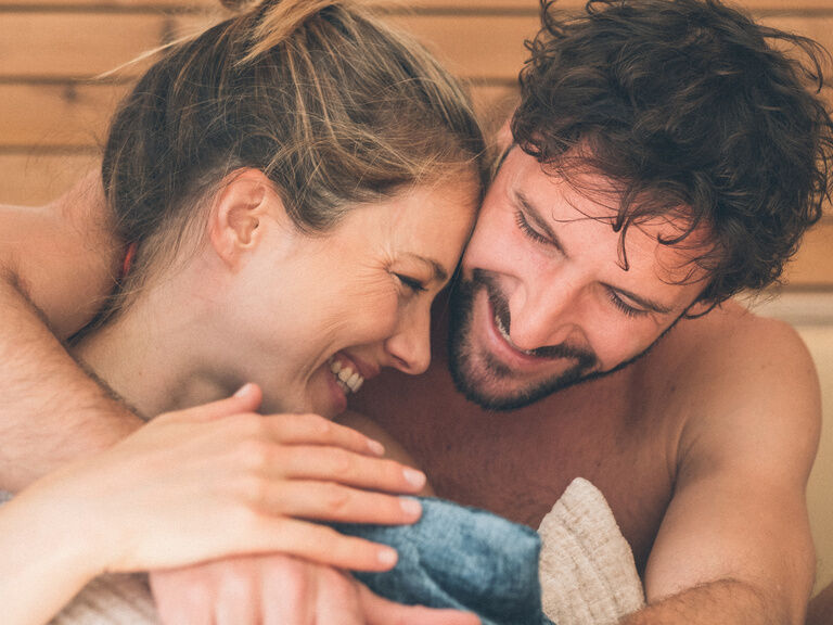 Ein Gäste-Paar hat Spaß. Der Mann umarmt die Frau von hinten in der Wasserwelt des Hotel Eibl-Brunner.