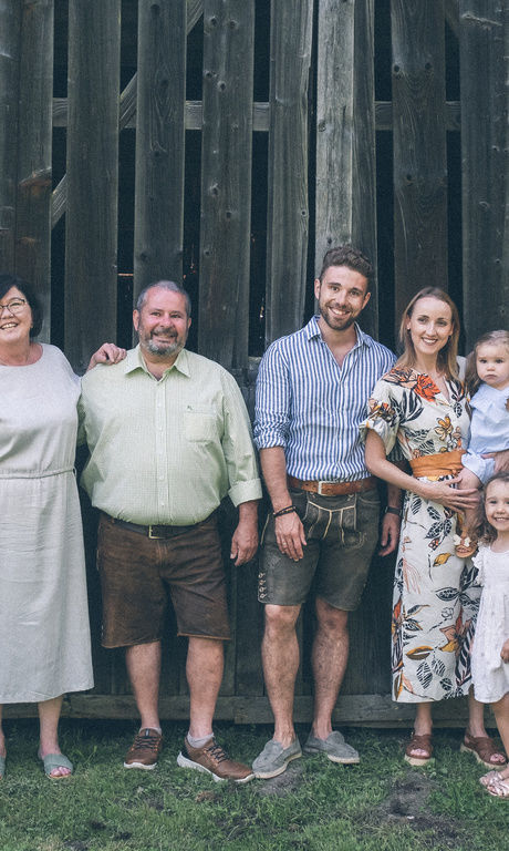 Familienbild der Familie Brunner vor einer Scheune mit Hund.