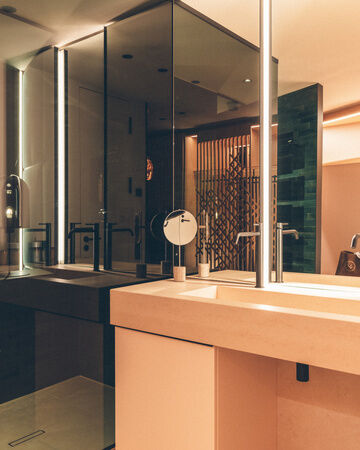 Helles Badezimmer mit begehbarer Dusche und großen Waschtisch mit Spiegel in der Wald Spa Suite des Hotel Eibl-Brunner.