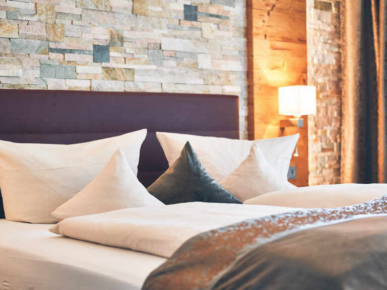 Detailaufnahme der gemütlichen Kissen auf dem Doppelbett im Doppelzimmer Falkenstein im Hotel Eibl-Brunner.