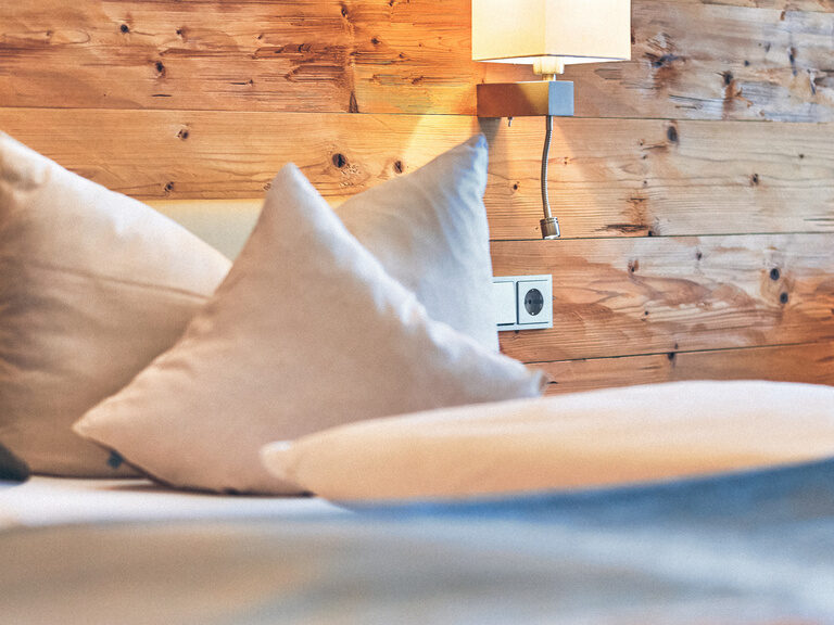 Doppelbett mit kuscheligen Kissen dekoriert.