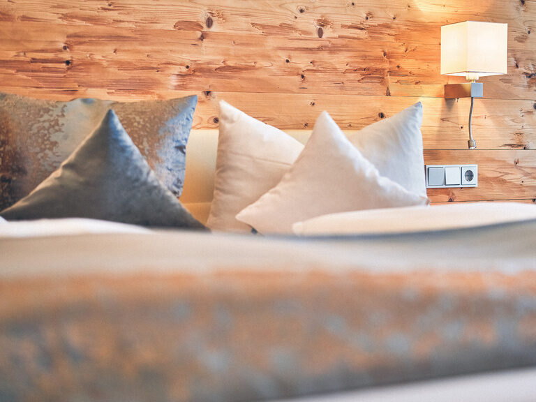 Doppelbett mit kuscheligen Kissen dekoriert.