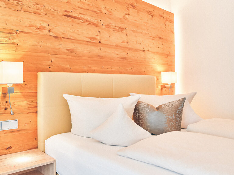 Doppelbett mit kuscheligen Kissen dekoriert.