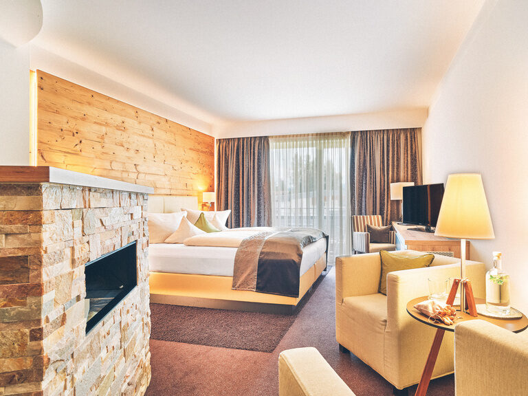 Doppelzimmer Arber im Hotel Eibl-Brunner - Blickrichtung Balkon mit Sitzgelegenheit und Doppelbett im Blick.