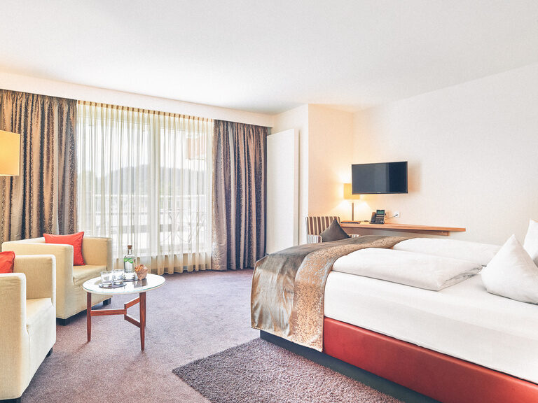 Gemütliches Doppelbett in einem Doppelzimmer des Hotel Eibl-Brunner, mit Blick richtung Balkon.