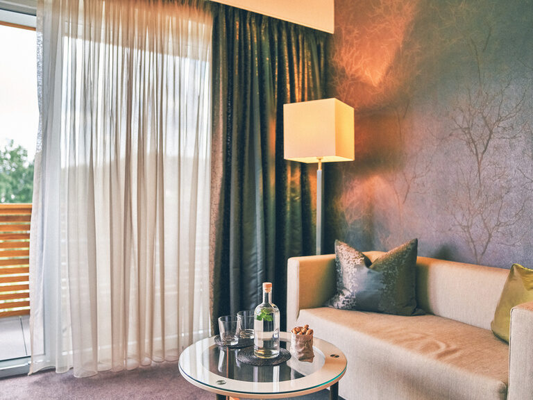 Gemütliche Sitzgelegenheit im Doppelzimmer Josefi mit Blick aus dem Fenster.