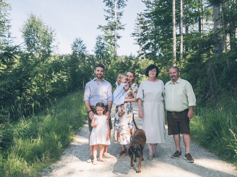 Familienbild mit der Familie Brunner mit 3 Generationen auf einem Feldweg beim Spaziergang.