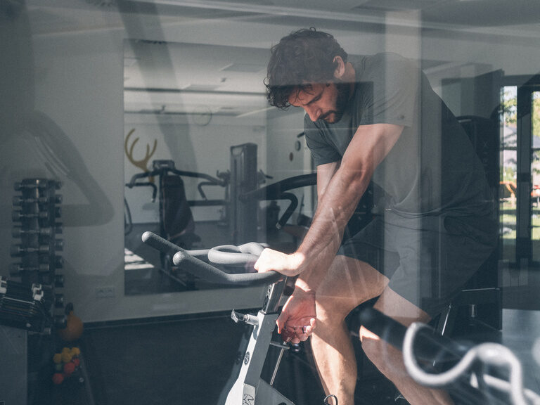 Gast auf Bike im Fitnessraum des Hotel Eibl-Brunner.