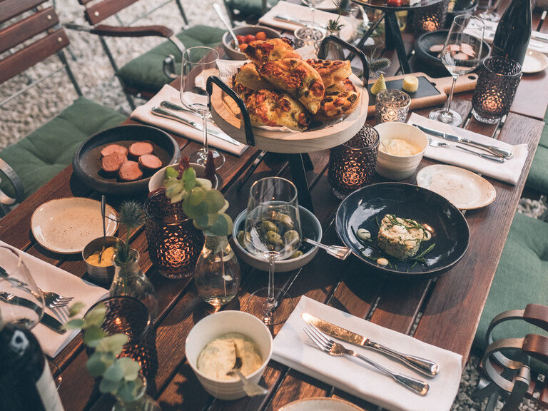 Verschiedene Gerichte und Speisen für ein gemeinsames Essen mit mehreren Personen im Hotel Garten.