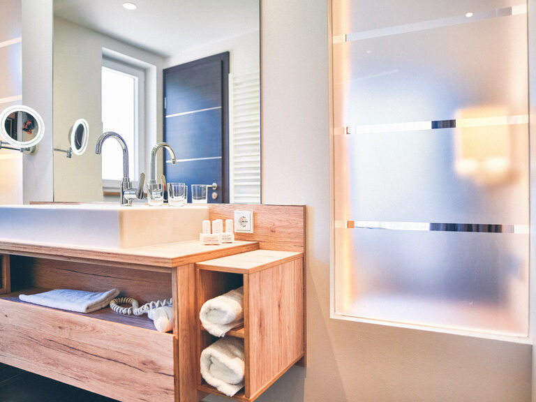 Hölzerner Unterbau des Waschtisches, im Badezimmer eines Doppelzimmers des Hotel Eibl-Brunner mit großen Spiegel.