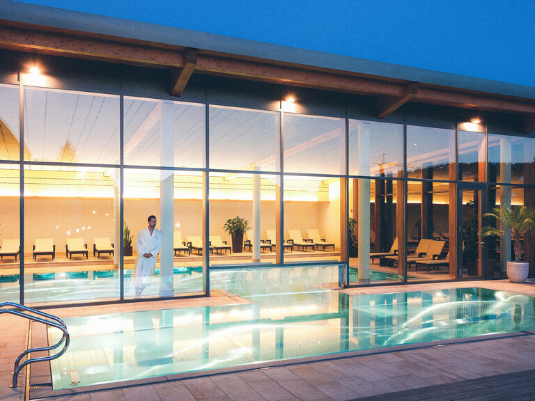 Außenpool mit Blick in den Innenpoolbereich der Wasserwelt im Hotel Eibl-Brunner.