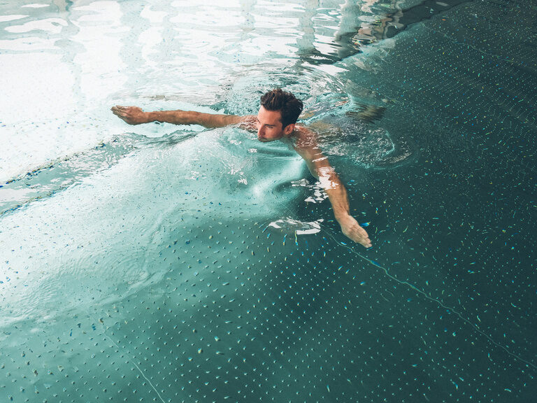 Mann schwimmt im Innenpool des Hotel Eibl-Brunner.