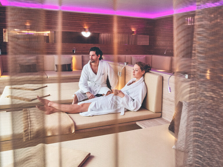 Gäste Paar entspannt auf den Ruheraumliegen im Saunabereich Hotel Eibl-Brunner.