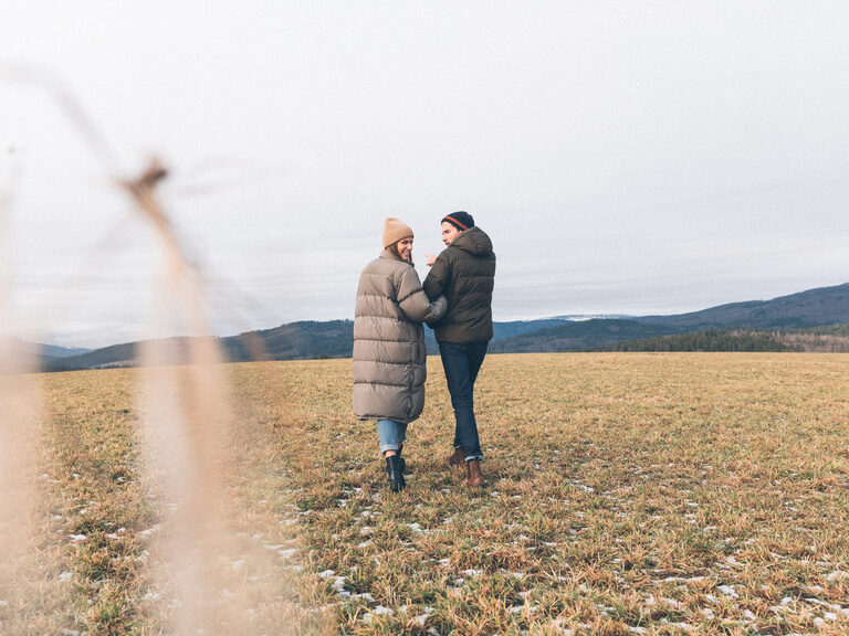 Ein Paar bei herbstlichen Temperaturen auf einem Feld in der Nähe des Hotel Eibl-Brunner.