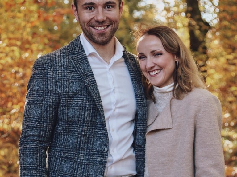 Fröhliches Paarbild von den Gastgebern des Hotel Eibl-Brunner, Diana und Stefan Brunner, im herbstlich-bunten Blätterwald.