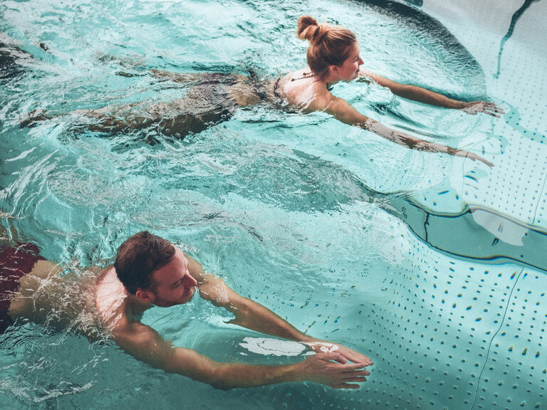 Gäste-Paar schwimmt in Pool des Hotel Eibl-Brunner.