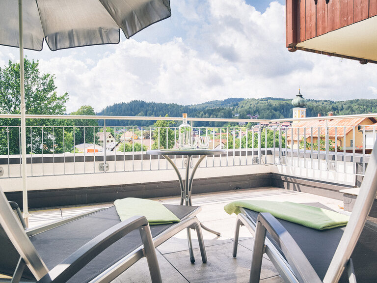 Sonnenliegen mit Blick über Frauenau auf dem Balkon des Doppelzimmer Lusen im Hotel Eibl-Brunner.
