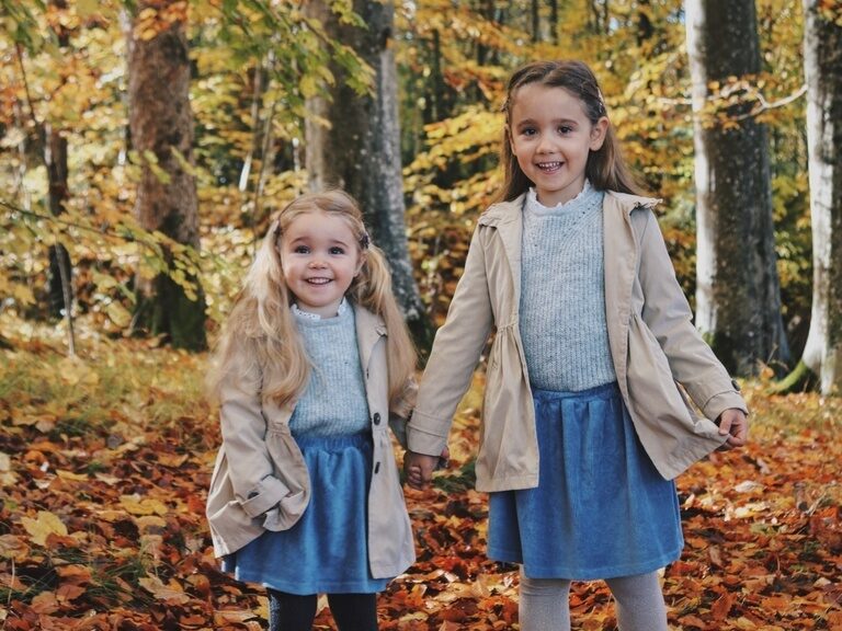 Fröhlich lächelnde Mädchen im Herbstwald des Bayerischen Wald.