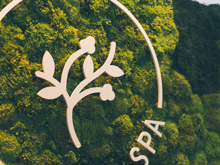Mooswand mit Wald-Spa Logo im Wellnessbereich des Hotel Eibl-Brunner.