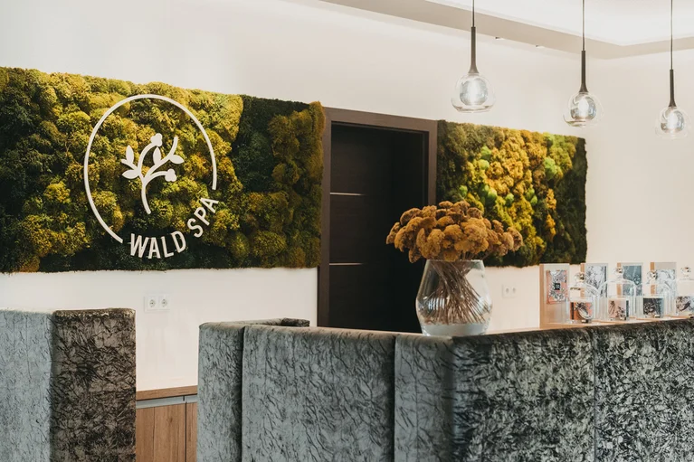 Rezeption im Wald Spa mit Mooswand und Blumenstrauß in Vase