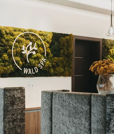 Rezeption im Wald Spa mit Mooswand und Blumenstrauß in Vase