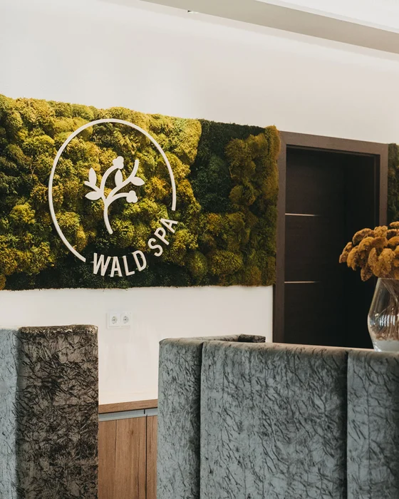 Rezeption im Wald Spa mit Mooswand und Blumenstrauß in Vase