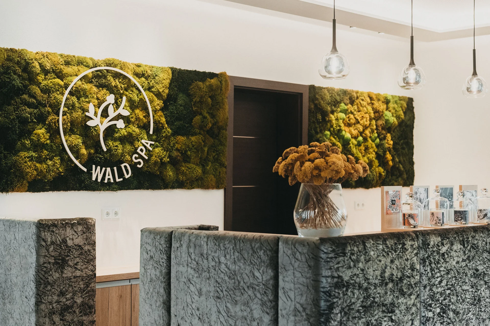 Rezeption im Wald Spa mit Mooswand und Blumenstrauß in Vase