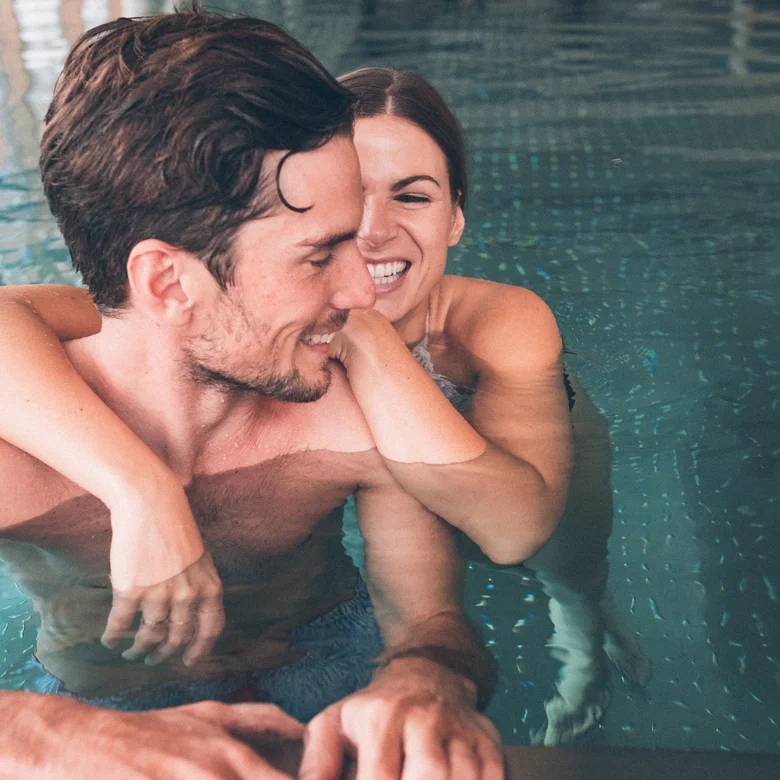 Glückliches Paar umarmt sich im Schwimmbad