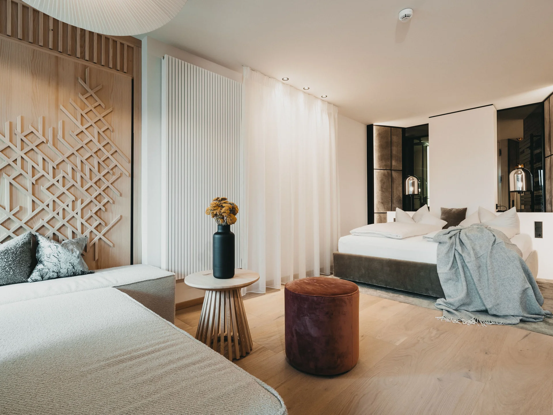 Modern eingerichtetes Hotelzimmer mit Bett, Sofa, Tisch und Dekoration