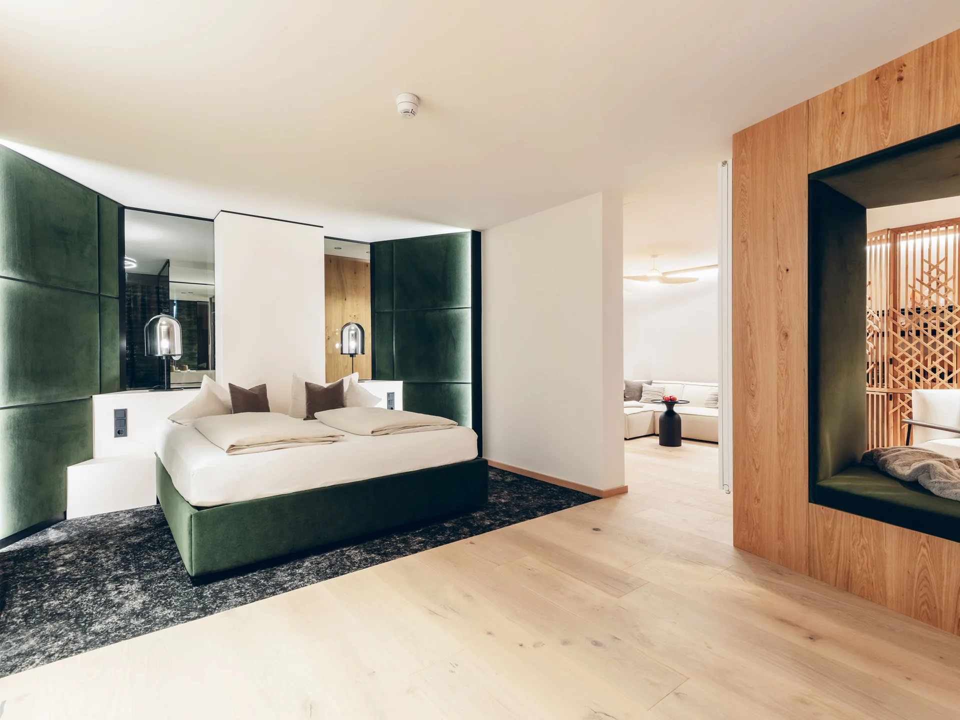 Modernes Hotelzimmer mit grünem Bett und Holzakzenten