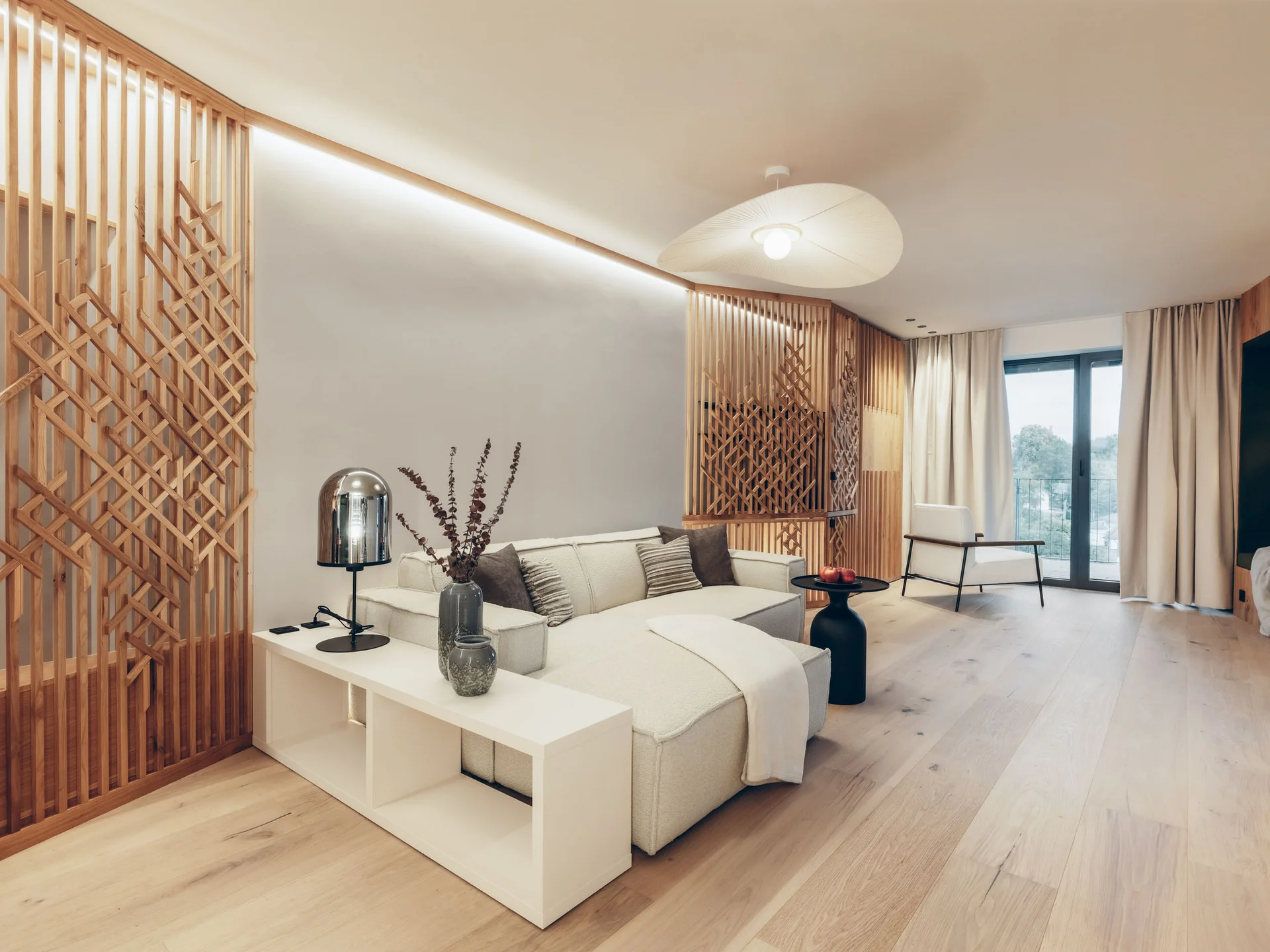 Modernes Wohnzimmer mit weißem Sofa, hölzernen Dekorationspaneelen und großem Fenster