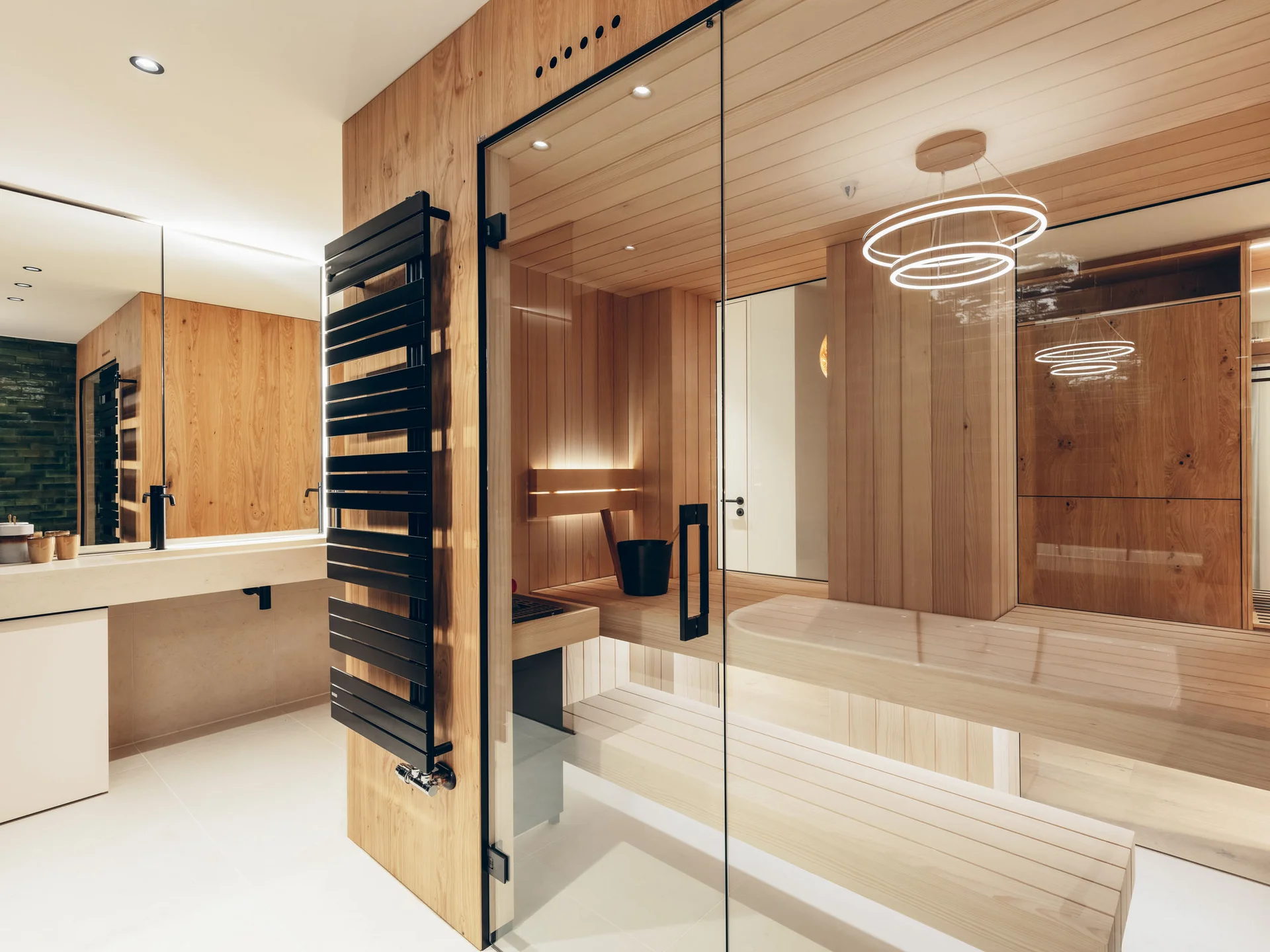 Moderner Wellnessbereich mit Sauna und Waschtisch in Holz und Glas